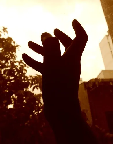 Silueta de una mano alzada hacia el cielo, símbolo de coraje